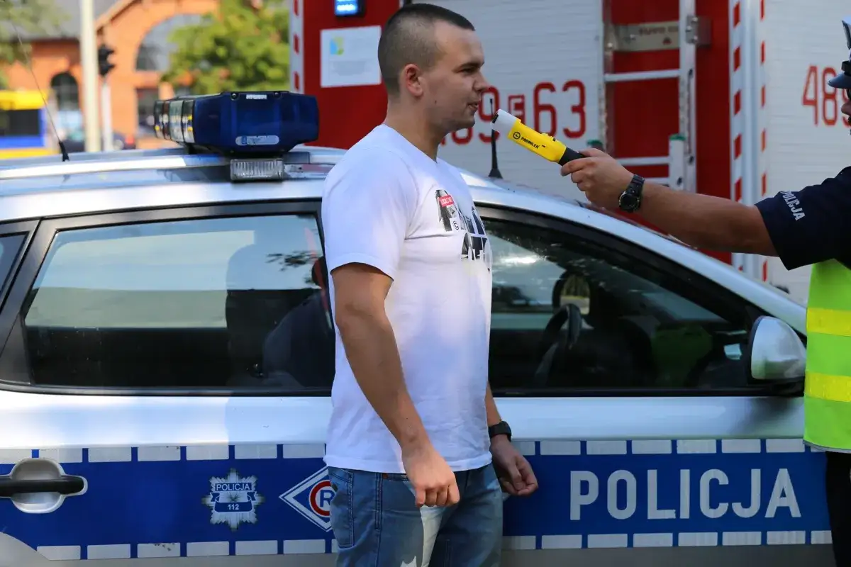 Policjant pokazuje świadectwo wzorcowania alkomatu